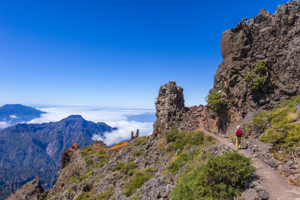 Woman walking on the footpath No. E7, from Pico de la Nieve to Roque de los Muchachos, in the Caldera de Taburiente National Park. This beautiful park is a ring of summits of 8 km in diameter with peaks reaching to 2000 meters, crossed by numerous well-marked trails. Canary Islands, Spain